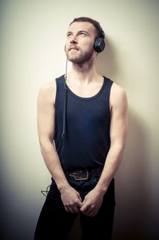 vintage portrait of fashion guy with headphones on gray background