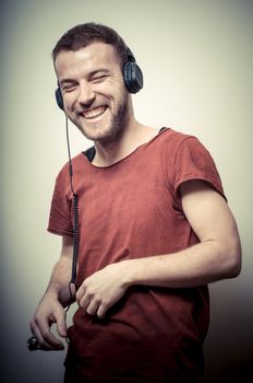 vintage portrait of fashion smiling guy with headphones on gray background