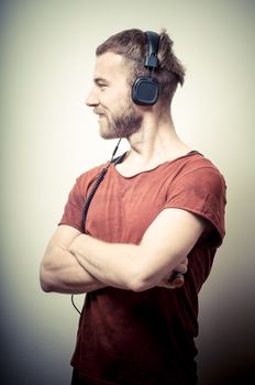 vintage portrait of fashion guy with headphones on gray background