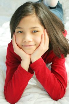 Child lying on bed thinking