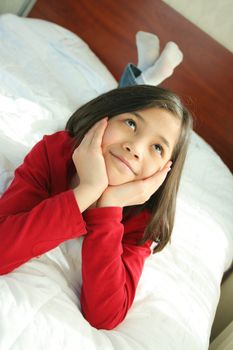 Child lying on bed thinking