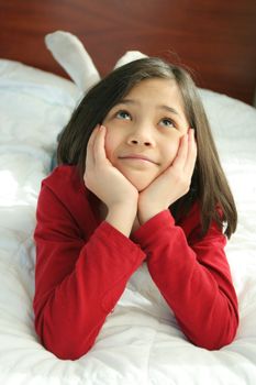 Child lying on bed thinking