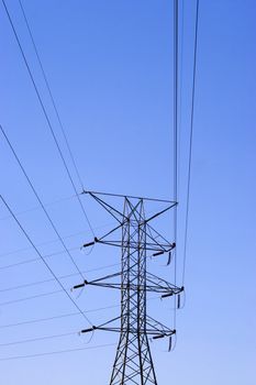 Some high power lines over a bright blue sky.