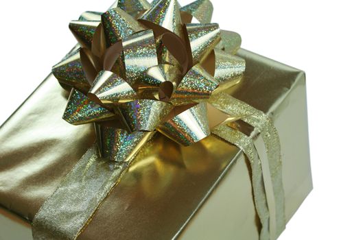 Luxurious gold gift wrapped with glittery golden bow and ribbons isolated on white