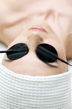 beauty salon, body care series. zone electrophoresis procedure applying on eyelids. selective focus.