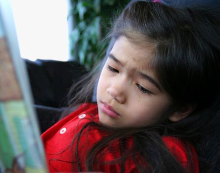 GIrl reading a story, looking sad at the sad part of story