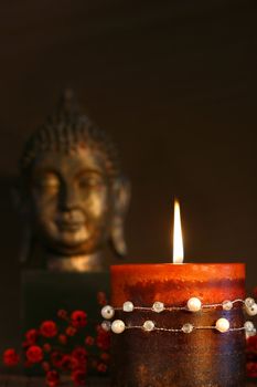 Zen candle and buddha statue with dark background