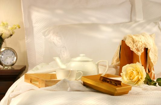 Tea in bed with chocolates and white sheets