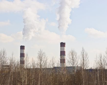 Thick smoke from the pipes against the backdrop of blue sky 