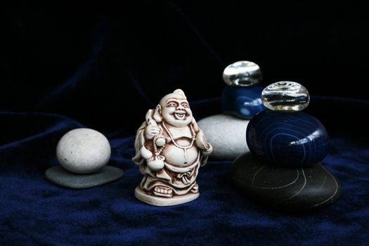 White, black and blue pebble, two glass spheres and Buddha figurine in Zen composition
