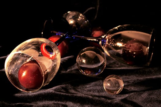 Glasses with plums both crystal and glass spheres on the black velvet