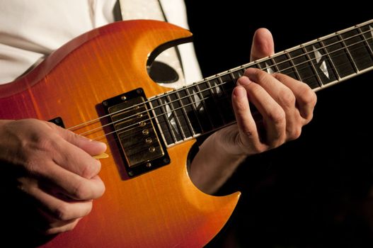 Close up on the hands of a guitar player with copy space in the background