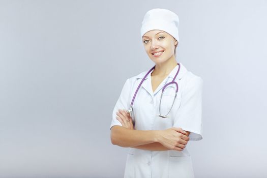 Smiling female doctor with stethoscope on a gray background