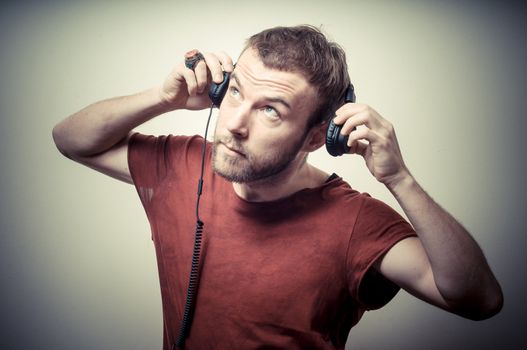 vintage portrait of fashion guy with headphones on gray background