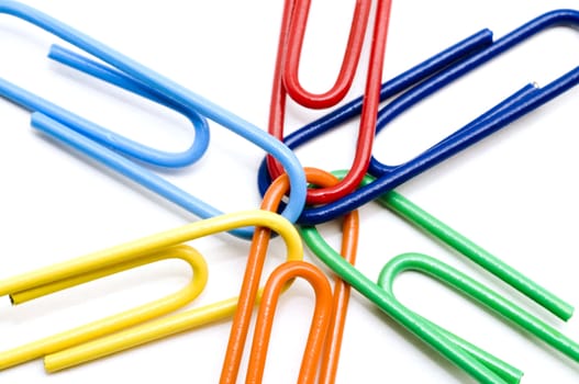 Joined multi colored paper clips on white background
