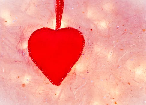 Red felt heart on a textured pale background