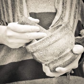Close up of someone's hands using a pestle and mortar