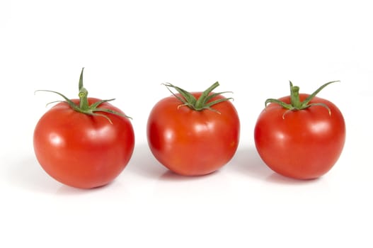 Three juicy ripe tomatoes isolated on a white background
