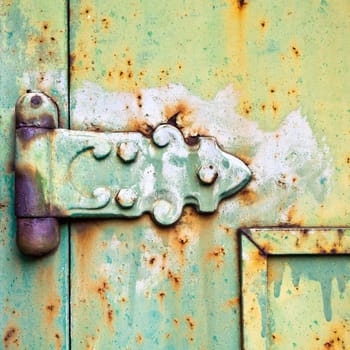An old patterned hinge with rust decay