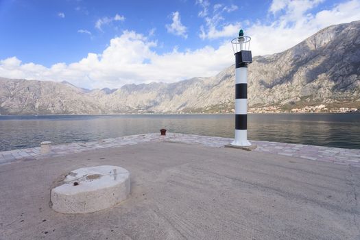 Lighthouse and carved stone overlooking Unesco protected Kotor Fjord Montenegro