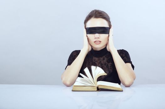 Lady with blindfold hearing the book pages. 