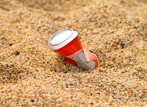 Environmental problem - Aluminium drink container in sand on seacoast at the sea