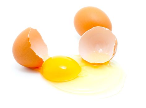 brown eggs on a white background. One egg is broken.