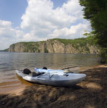 Composite of kayak on the beach with the Bon Echo cliffs in the background