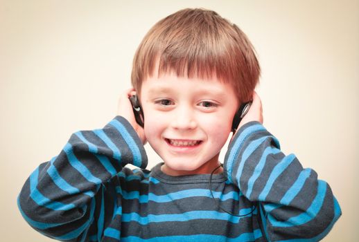 A young boy listening to music with earphones