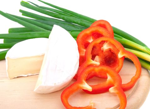 Wheel of French cheese with vegetables (onion, paprika), on white background