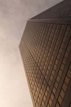 Selective focus on the bottom floors of a golden sunset colored skyscraper