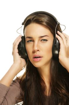 serious looking woman listening to music on white background