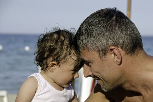 Father and Daughter looking each other on the Beach, Italy