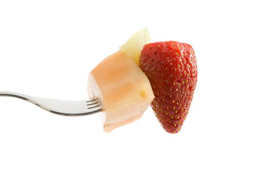 Melon and a strawberry on a fork isolated on a white background