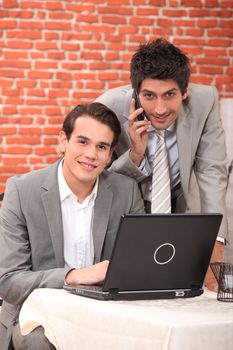 Young men using a laptop in a restaurant