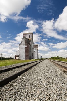 Old grain elevator located in rural Saskatchewan with railway line perspective