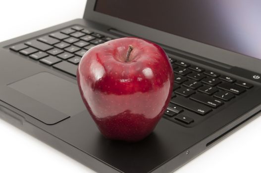 Red apple placed on a computer laptop keyboard