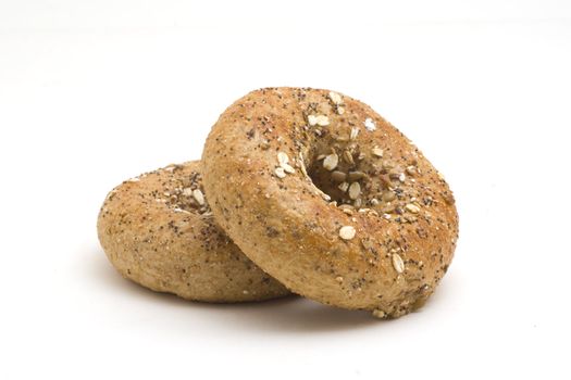 Close photo of two whole grain bagels isolated on white background