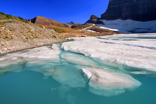 Ice floats in a pond by the Grinnell Glacier in Glacier National Park of Montana.