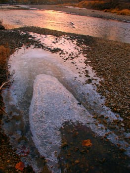 Sunlight gleams off icy waters of the Kishwaukee River in Illinois.