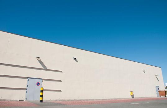 exterior view of a industrial warehouse building with a gorgeous blue sky