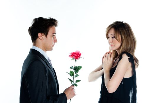 A young man gives a beautiful young woman, a flower in honor of the holiday