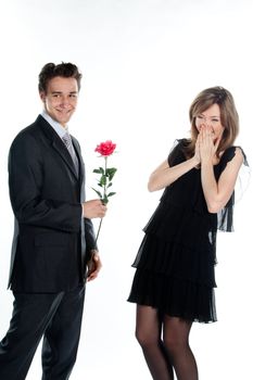 A young man gives a beautiful young woman, a flower in honor of the holiday