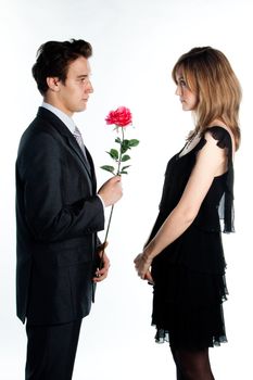 A young man gives a beautiful young woman, a flower in honor of the holiday