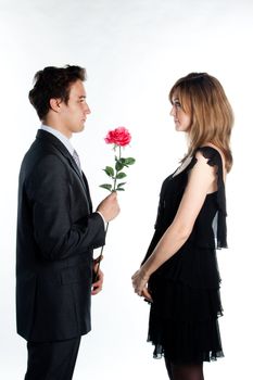 A young man gives a beautiful young woman, a flower in honor of the holiday