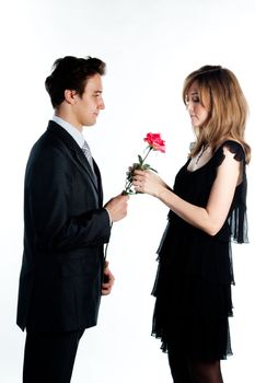 A young man gives a beautiful young woman, a flower in honor of the holiday