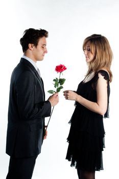A young man gives a beautiful young woman, a flower in honor of the holiday
