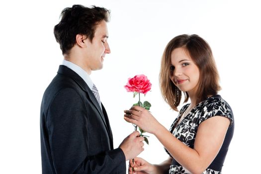 A young man gives a beautiful young woman, a flower in honor of the holiday