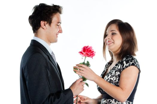 A young man gives a beautiful young woman, a flower in honor of the holiday