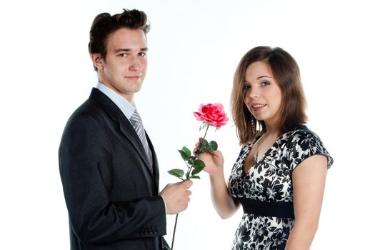 A young man gives a beautiful young woman, a flower in honor of the holiday